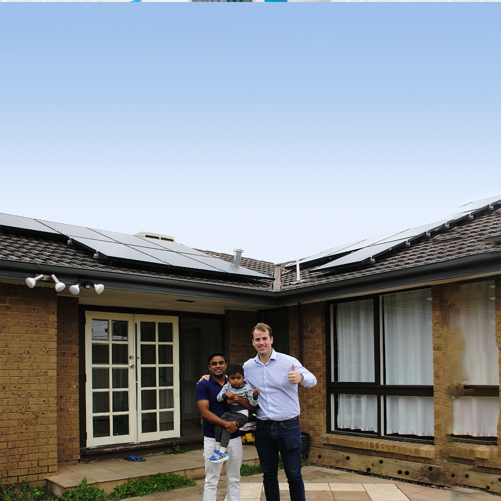 Jackson Taylor with a local resident, in front of their house with solar panels.